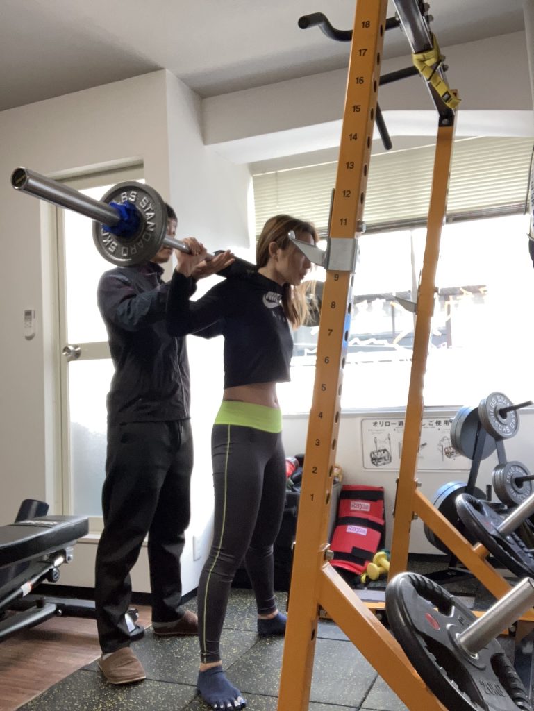 Speranzaパーソナルジムでスクワットフォームをサポートする様子